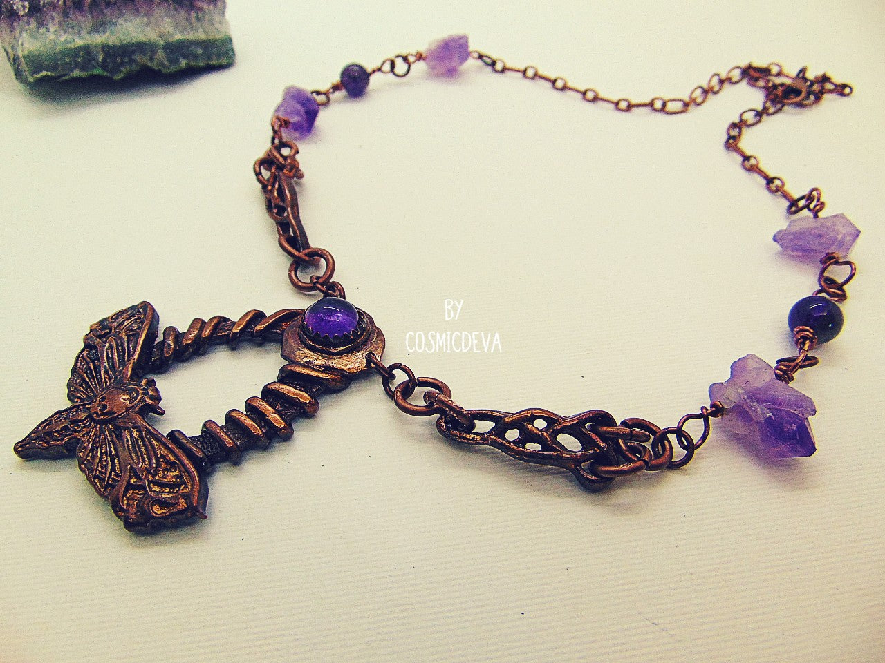 Handcrafted detailed death head hawk Moth (Acherontia) made of solid copper with a natural amethyst cabochon setting. The pendant is the focal point of a chain necklace with drilled natural raw amethyst gemstones, natural amethyst round beads and two completely handcrafted copper Celtic knot design findings.