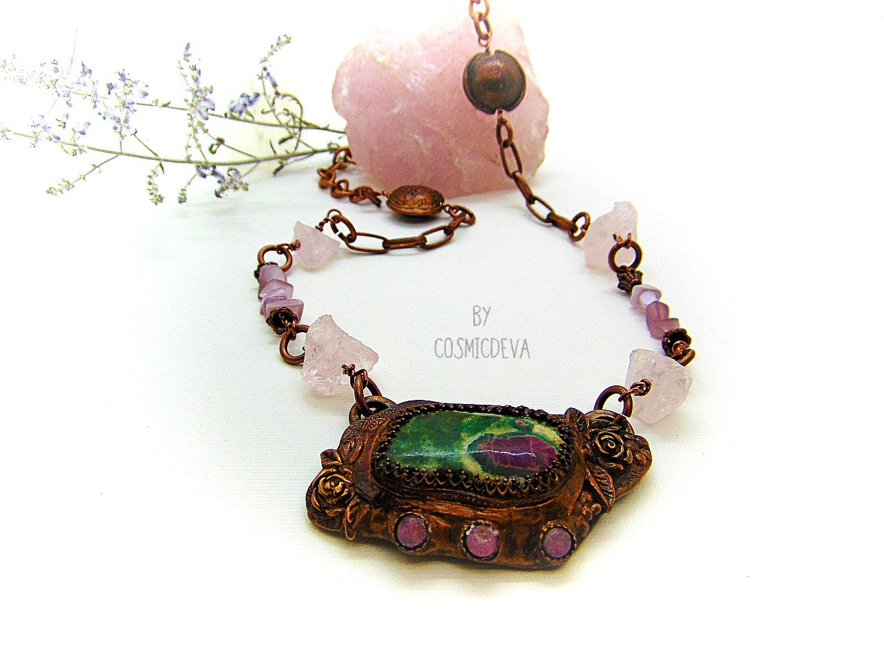 One of a kind handmade necklace with a hand sculptured solid copper pendant featuring a beautiful ruby in fuchsite gemstone cabochon in a bezel setting, surrounded with roses and natural raw pink tourmaline gemstones. This ruby in fuchsite statement necklace pendant suspends from a copper chain with accentual raw rose quartz crystal gemstones and handcrafted copper lentil beads.