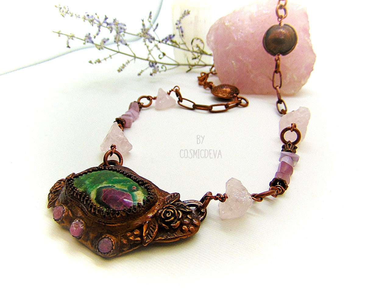 One of a kind handmade necklace with a hand sculptured solid copper pendant featuring a beautiful ruby in fuchsite gemstone cabochon in a bezel setting, surrounded with roses and natural raw pink tourmaline gemstones. This ruby in fuchsite statement necklace pendant suspends from a copper chain with accentual raw rose quartz crystal gemstones and handcrafted copper lentil beads.