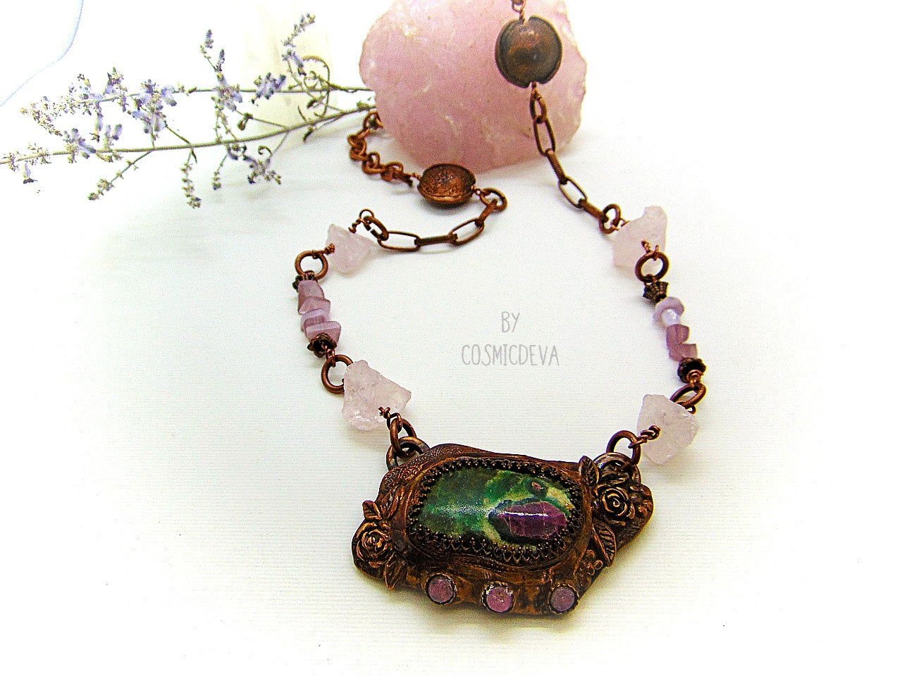 One of a kind handmade necklace with a hand sculptured solid copper pendant featuring a beautiful ruby in fuchsite gemstone cabochon in a bezel setting, surrounded with roses and natural raw pink tourmaline gemstones. This ruby in fuchsite statement necklace pendant suspends from a copper chain with accentual raw rose quartz crystal gemstones and handcrafted copper lentil beads.