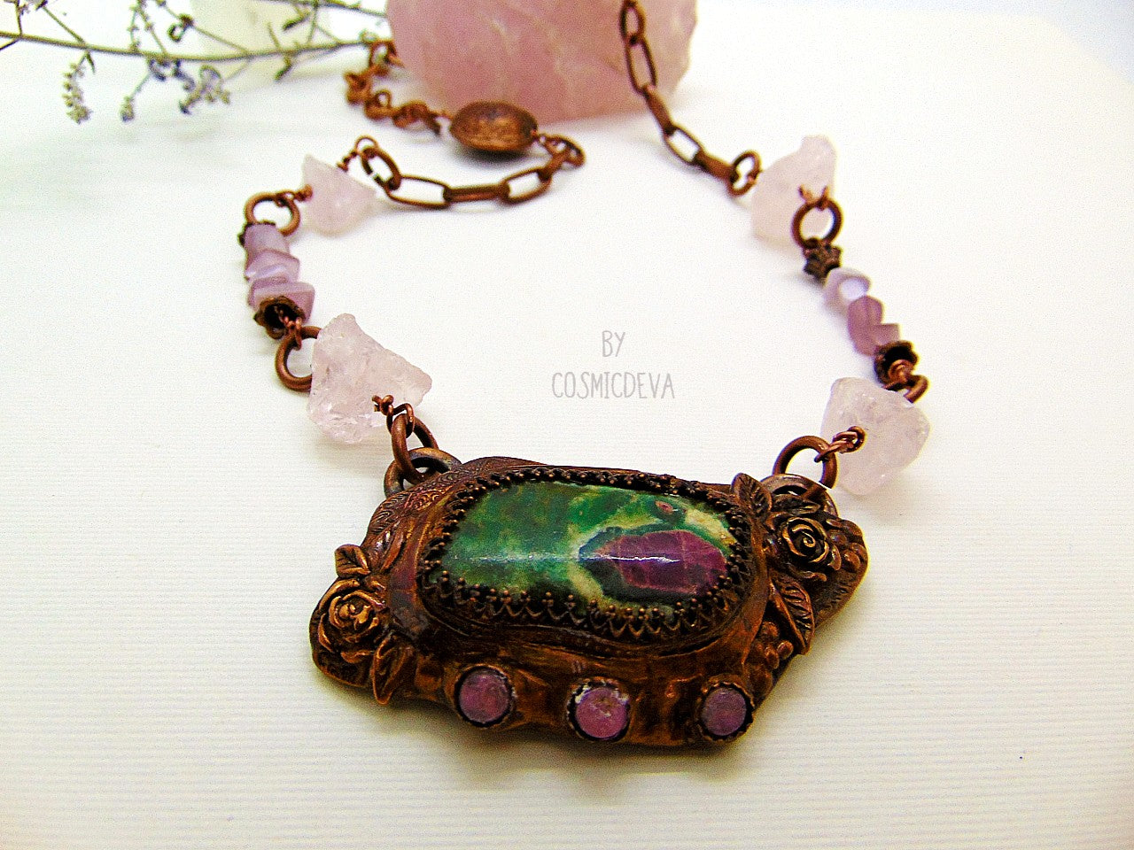 One of a kind handmade necklace with a hand sculptured solid copper pendant featuring a beautiful ruby in fuchsite gemstone cabochon in a bezel setting, surrounded with roses and natural raw pink tourmaline gemstones. This ruby in fuchsite statement necklace pendant suspends from a copper chain with accentual raw rose quartz crystal gemstones and handcrafted copper lentil beads.