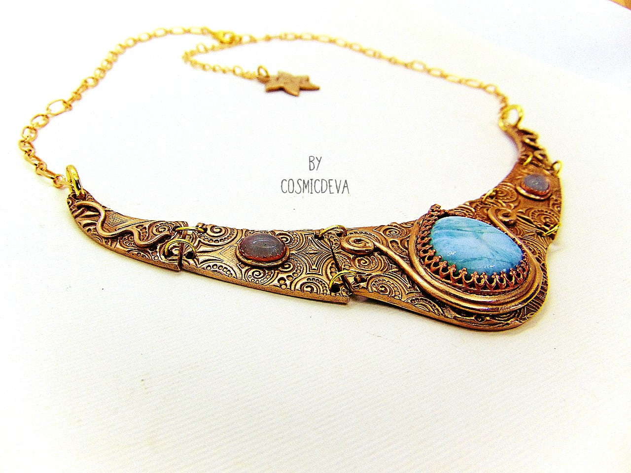 Distinguish yourself with this stunning Ancient Style Choker Collar With Larimar Gold Bronze Necklace. Hand-formed with solid gold bronze, it exudes elegance with the aquamarine and larimar gemstones embedded in its center. Feel luxurious and be the envy of all! A unique adornment that will adore to wear in all occasions.