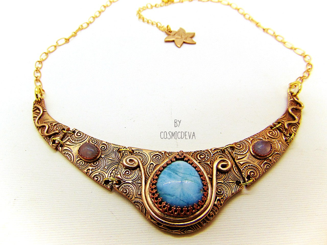 Distinguish yourself with this stunning Ancient Style Choker Collar With Larimar Gold Bronze Necklace. Hand-formed with solid gold bronze, it exudes elegance with the aquamarine and larimar gemstones embedded in its center. Feel luxurious and be the envy of all! A unique adornment that will adore to wear in all occasions.