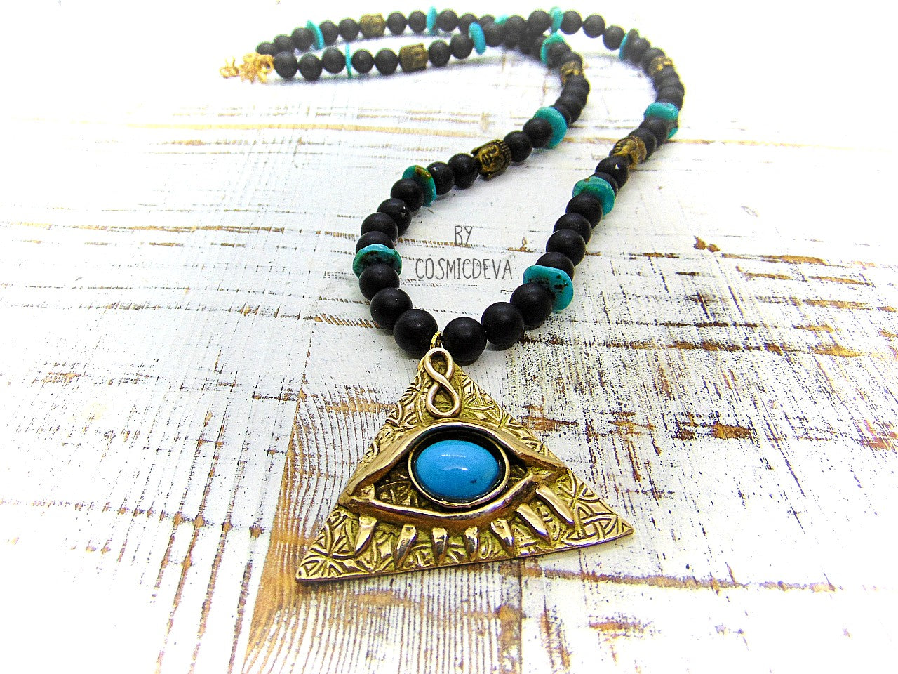 Adorn yourself with this mystical completely hand sculptured bronze All Seeing Eye necklace and protect your soul with its natural turquoise and black onyx gemstones. Feel the spiritual energy of its Infinity symbol and antique brass buddha head beads, inspiring knowledge and positivity. Experience the power of the eye each time you wear it!