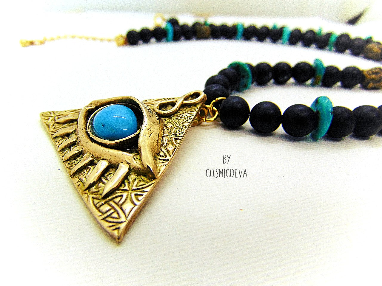 Adorn yourself with this mystical completely hand sculptured bronze All Seeing Eye necklace and protect your soul with its natural turquoise and black onyx gemstones. Feel the spiritual energy of its Infinity symbol and antique brass buddha head beads, inspiring knowledge and positivity. Experience the power of the eye each time you wear it!