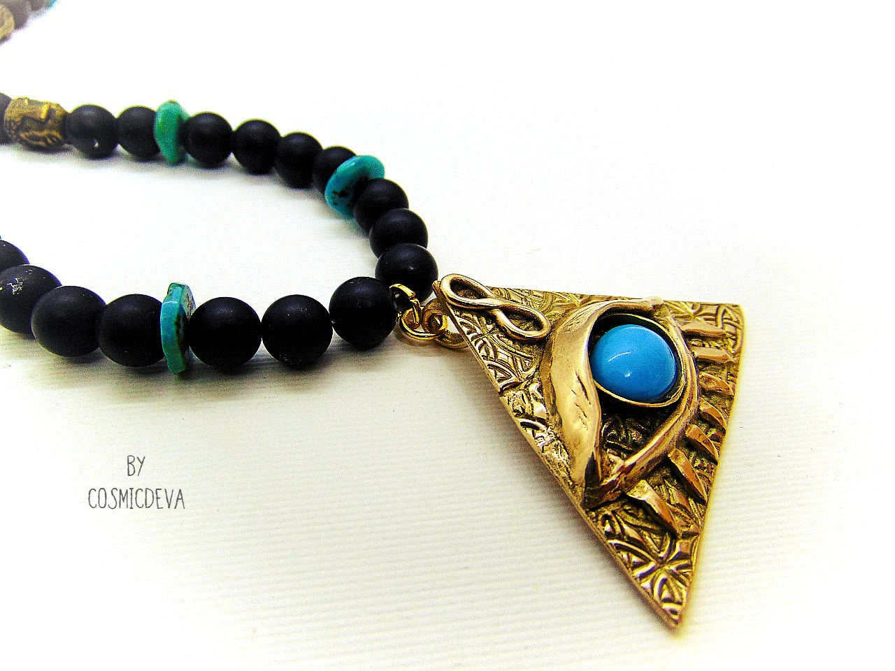 Adorn yourself with this mystical completely hand sculptured bronze All Seeing Eye necklace and protect your soul with its natural turquoise and black onyx gemstones. Feel the spiritual energy of its Infinity symbol and antique brass buddha head beads, inspiring knowledge and positivity. Experience the power of the eye each time you wear it!