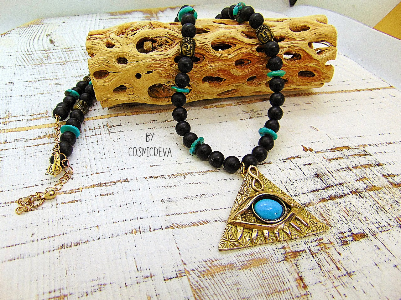 Adorn yourself with this mystical completely hand sculptured bronze All Seeing Eye necklace and protect your soul with its natural turquoise and black onyx gemstones. Feel the spiritual energy of its Infinity symbol and antique brass buddha head beads, inspiring knowledge and positivity. Experience the power of the eye each time you wear it!