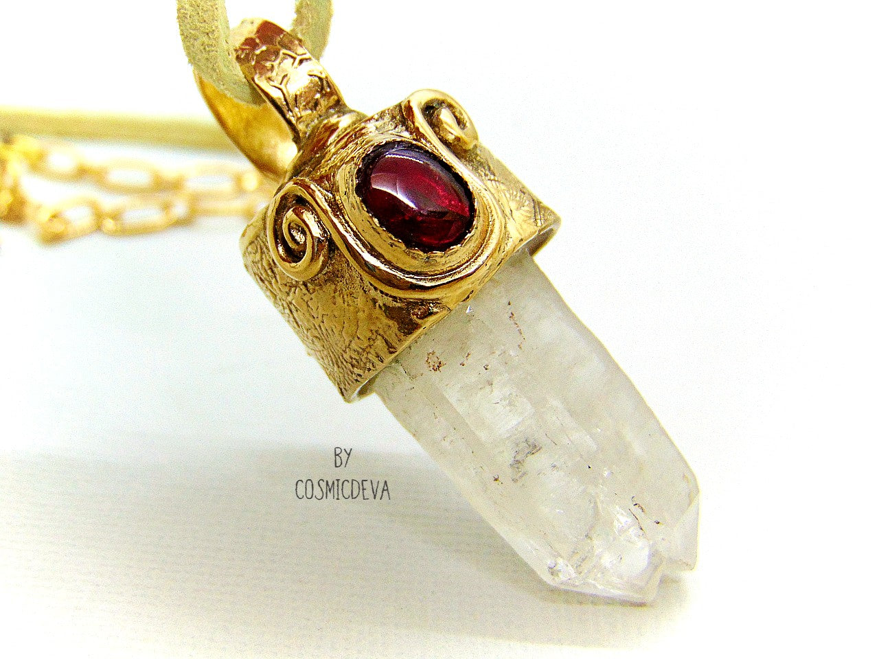 One of a kind completely hand sculptured gold bronze pendant with clear natural twin pointed crystal quartz wand and a lovely red ruby setting. A textured spirit animal dolphin is shown on the backside of the gold bronze pendant. Twin pointed crystals also known as soulmate crystals are two points one body, representing co- in-joined twins or entwined souls. Carry and meditate on a piece of twin pointed quartz to attract your soulmate.