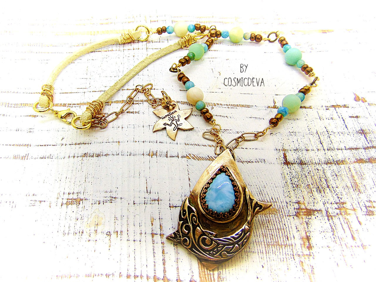 Bring harmony to your life with this beautiful Dolphin Spirit Animal Larimar Bronze Necklace. Handcrafted from solid bronze and adorned with a larimar gemstone, this one-of-a-kind pendant symbolizes the wisdom of Atlantis and healing power of dolphins - sure to bring peace and balance to your life. Finished with white leather and aqua colored jasper and amazonite gemstone beads.