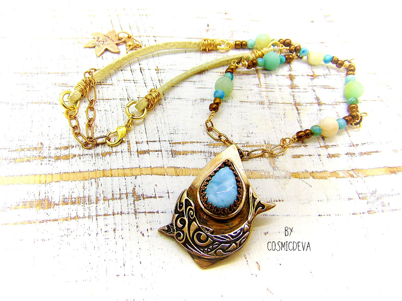 Bring harmony to your life with this beautiful Dolphin Spirit Animal Larimar Bronze Necklace. Handcrafted from solid bronze and adorned with a larimar gemstone, this one-of-a-kind pendant symbolizes the wisdom of Atlantis and healing power of dolphins - sure to bring peace and balance to your life. Finished with white leather and aqua colored jasper and amazonite gemstone beads.