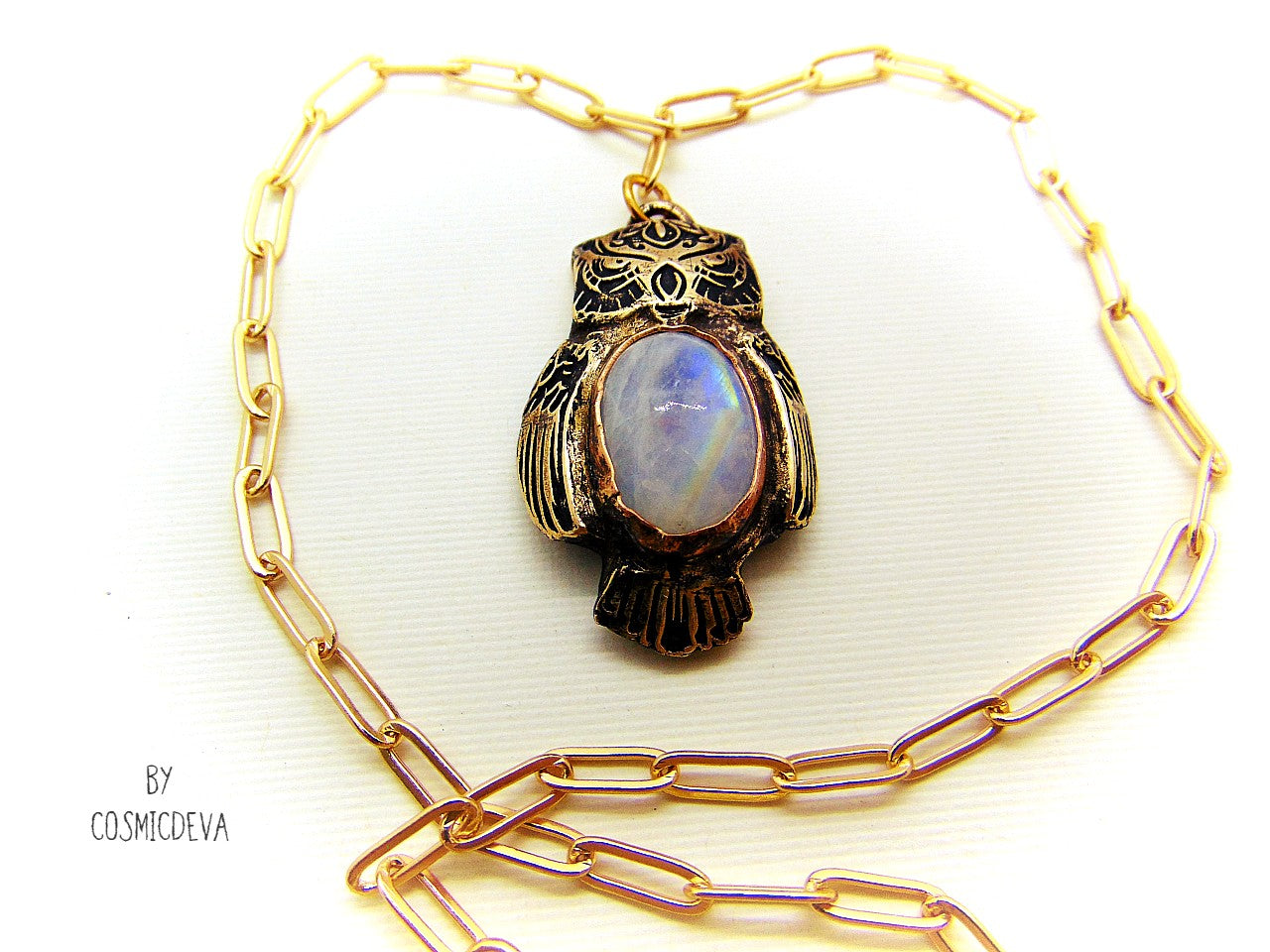 Cute one of a kind complete handcrafted and kiln fired gold bronze spirit animal owl with gorgeous rainbow moonstone bezel setting in the center. The backside of the pendant is also a owl and carries the cosmicdeva logo.