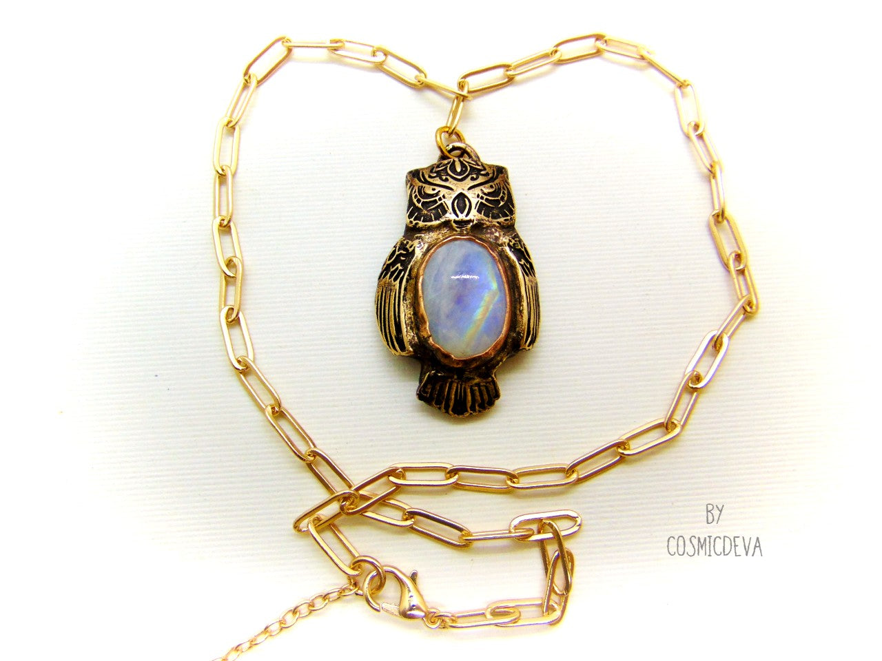 Cute one of a kind complete handcrafted and kiln fired gold bronze spirit animal owl with gorgeous rainbow moonstone bezel setting in the center. The backside of the pendant is also a owl and carries the cosmicdeva logo.