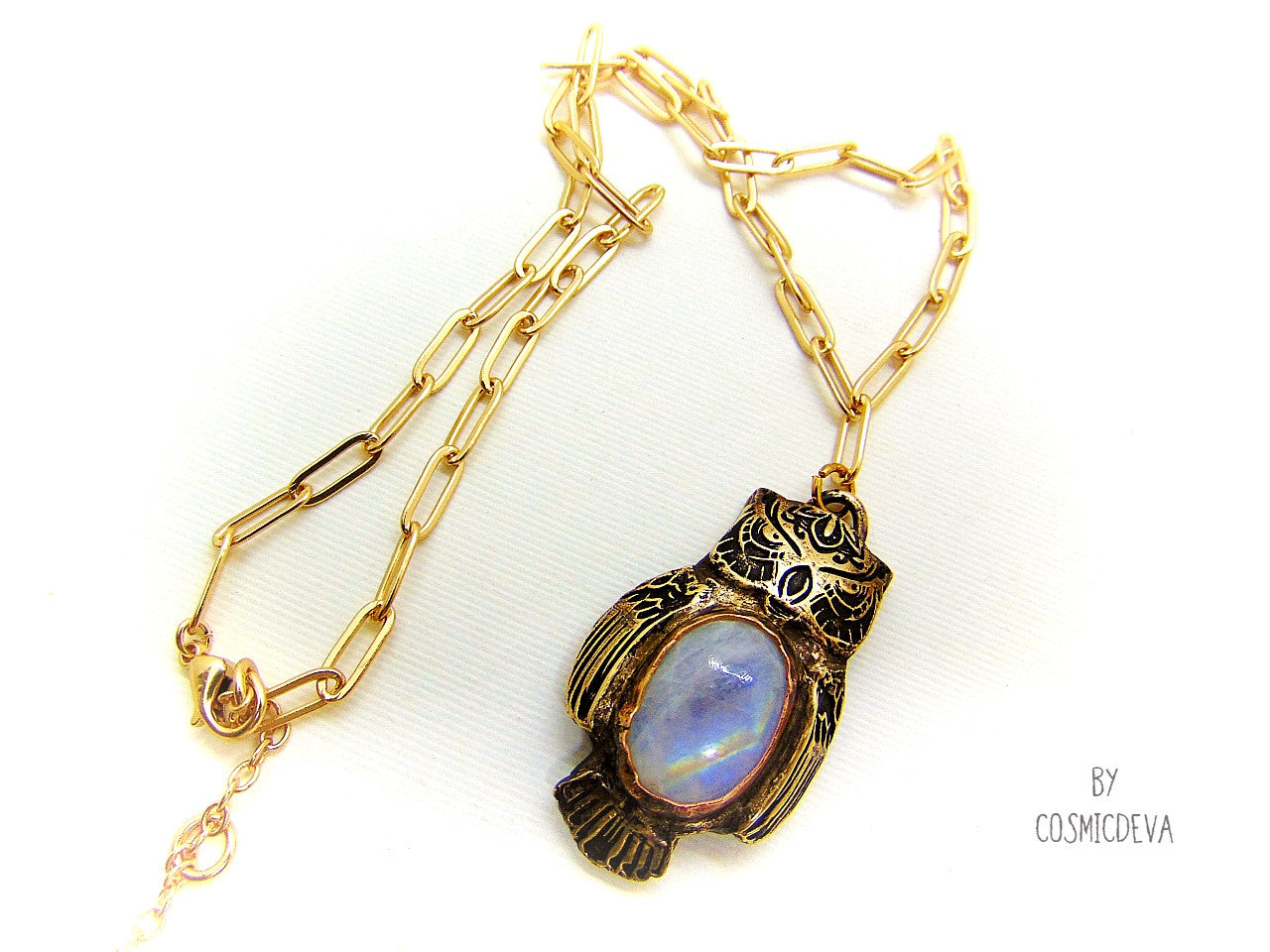 Cute one of a kind complete handcrafted and kiln fired gold bronze spirit animal owl with gorgeous rainbow moonstone bezel setting in the center. The backside of the pendant is also a owl and carries the cosmicdeva logo.