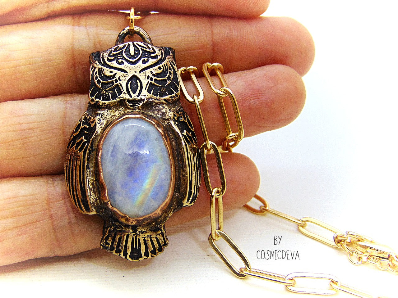 Cute one of a kind complete handcrafted and kiln fired gold bronze spirit animal owl with gorgeous rainbow moonstone bezel setting in the center. The backside of the pendant is also a owl and carries the cosmicdeva logo.