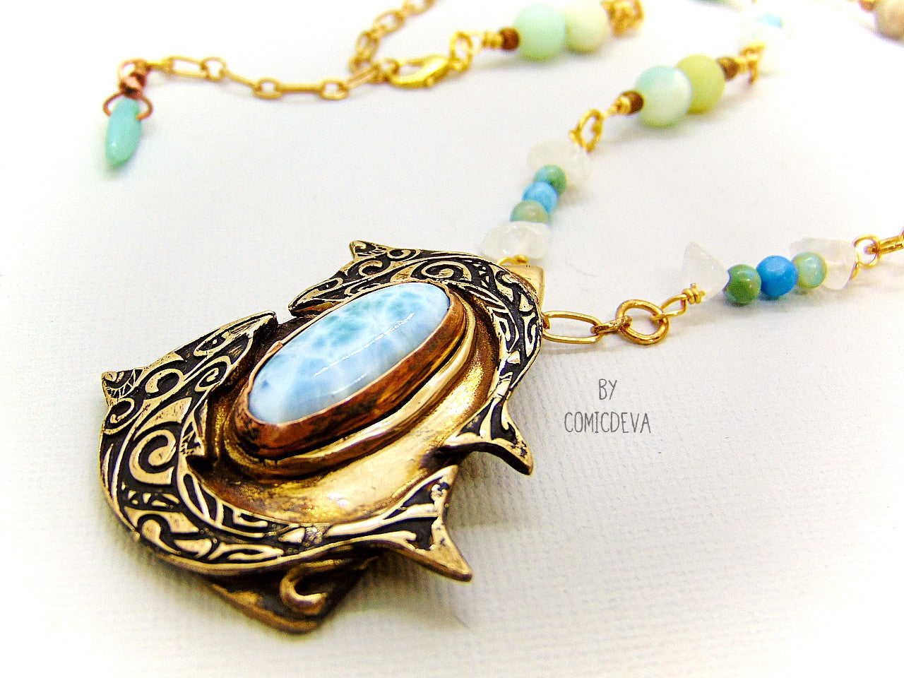 Bring harmony to your life with this beautiful Larimar Dancing Dolphins Bronze Necklace. Handcrafted with solid gold bronze and adorned with a dazzling aqua larimar gemstone, this one-of-a-kind pendant evokes the timeless wisdom of Atlantis and the healing power of dolphins. Finished with aqua jasper, clear quartz and amazonite gemstone beads, this necklace is a stylish and meaningful choice!