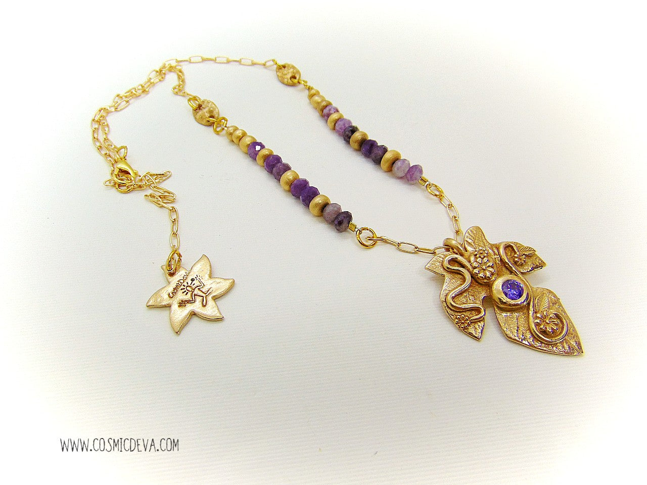 Playful handcrafted fig leaf with an Amethyst in the center and adorned with flowers and swirls. The dainty 18–21-inch necklace is strung with small facetted raw natural lepidolite gemstone rondelle beads and hand formed gold bronze pearls and connectors. I created and casted this leaf with a small fig tree leaf from our garden.