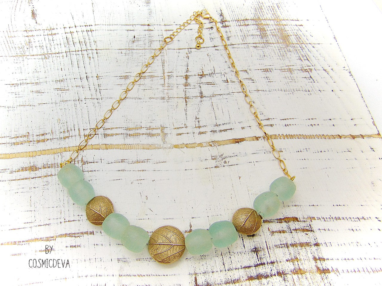 This is a truly unique and elegant botanical necklace. The hand formed gold bronze natural leaf lentil beads are made from an imprint of a leaf which I picked from a bush in my backyard. This organic gold bronze necklace is adorned with beautiful recycled ocean aqua blue glass beads.