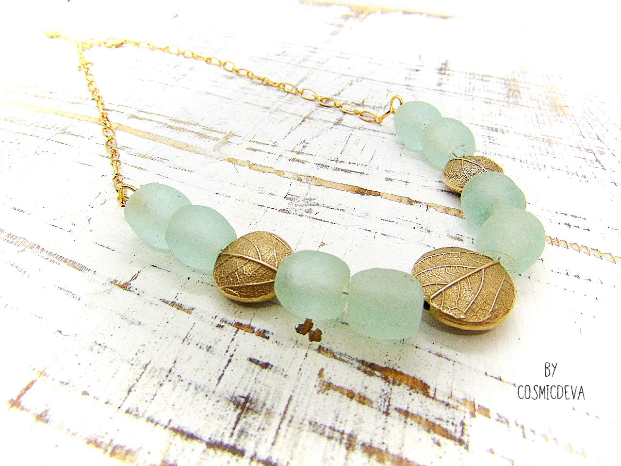 This is a truly unique and elegant botanical necklace. The hand formed gold bronze natural leaf lentil beads are made from an imprint of a leaf which I picked from a bush in my backyard. This organic gold bronze necklace is adorned with beautiful recycled ocean aqua blue glass beads.