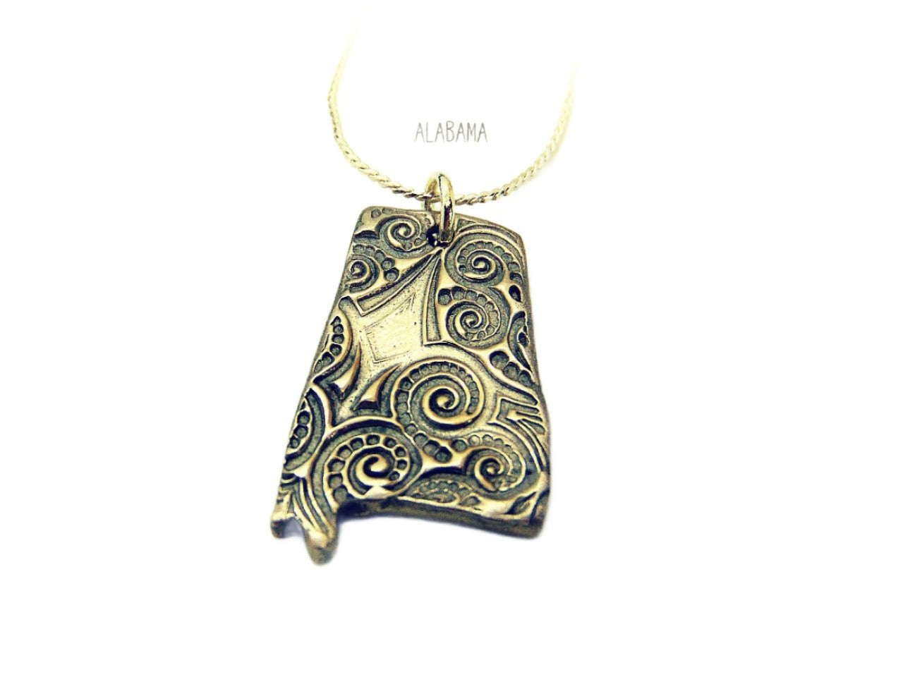 handcrafted and kiln fired Alabama State shaped pendant made of silver bronze.  This Alabama pendant dangles from a 20-inch silver plated chain.  The backside of the pendant is signed by CosmicDeva.