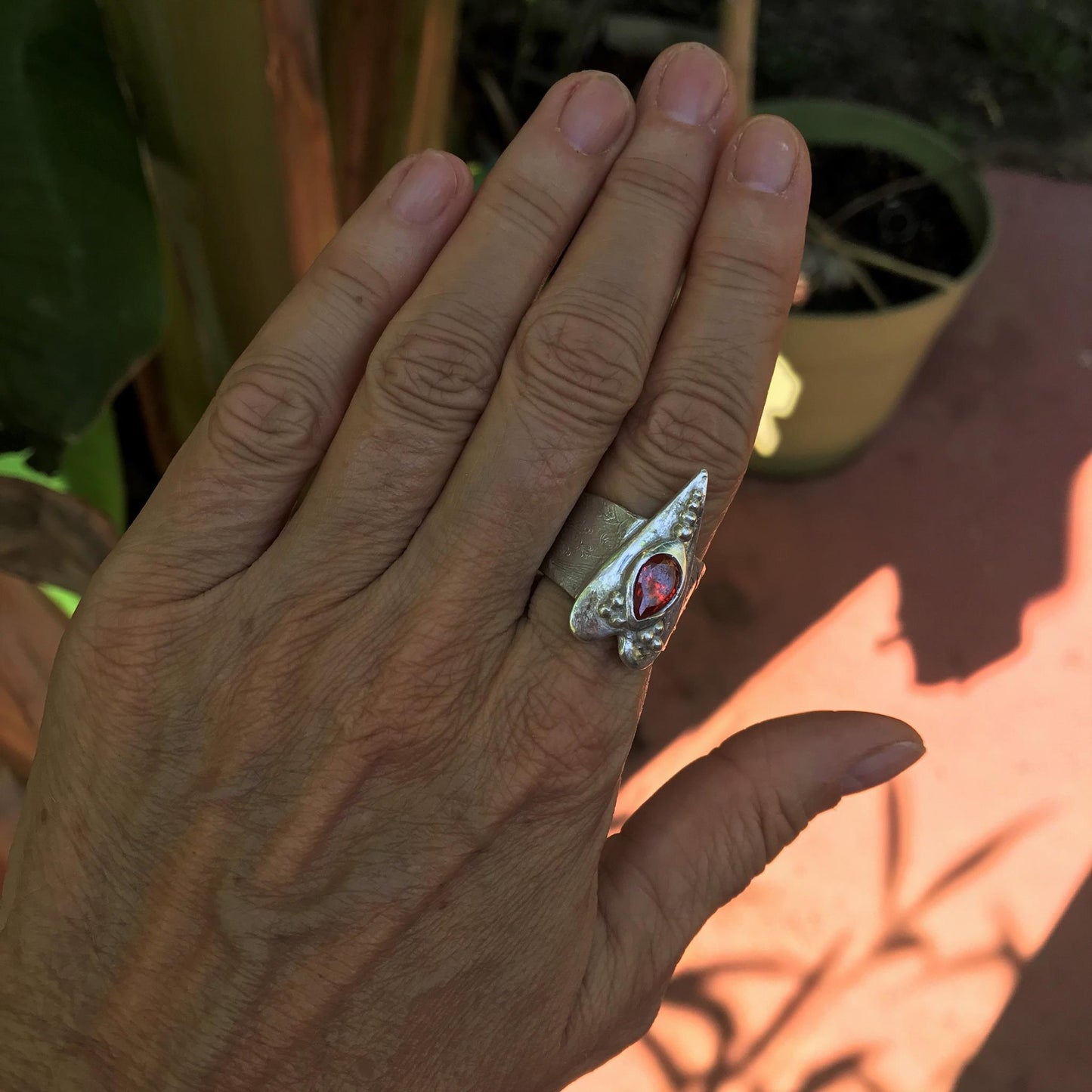 The heart is a symbol of love between two souls. This handcrafted wide ring shank sterling silver ring with floral texture featuring a large heart and 6 x 9 mm pear shaped red fire opal Cubic Zirconia gemstone . This Ring is made of pure .950 sterling silver and hallmarked as it.  CosmicDeva